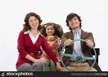 Studio portrait of happy family in imaginary car