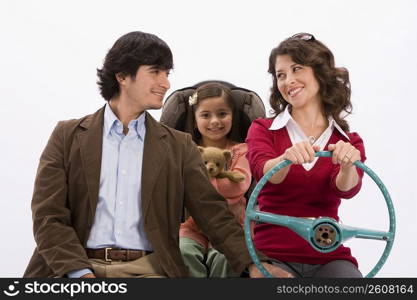 Studio portrait of happy family in imaginary car