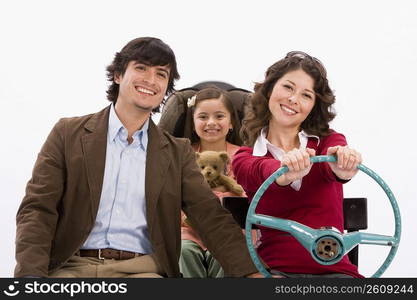 Studio portrait of happy family in imaginary car