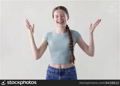 Studio Portrait Of Happy Smiling And Confident Teenage Girl With Arms Outstretched And Eyes Closed