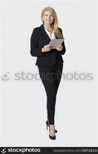 Studio Portrait Of Mature Businesswoman Holding Digital Tablet