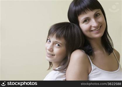 Studio portrait of mother and daughter, smiling