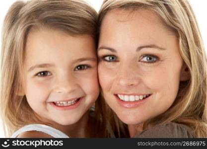 Studio Portrait Of Mother Hugging Young Daughter