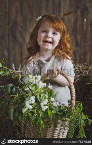 Studio portrait of red-haired little girls in the hay.. Small girl standing among the hay in the Studio 6139.