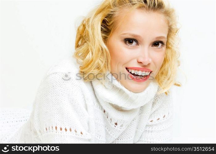 studio portrait of smiling blonde in white sweater