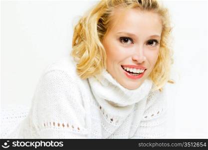 studio portrait of smiling blonde in white sweater
