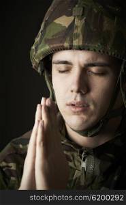 Studio Portrait Of Soldier In Uniform Praying
