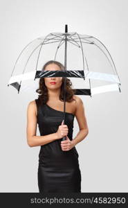 Studio portrait of woman in black dress with umbrella