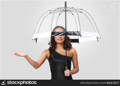 Studio portrait of woman in black dress with umbrella