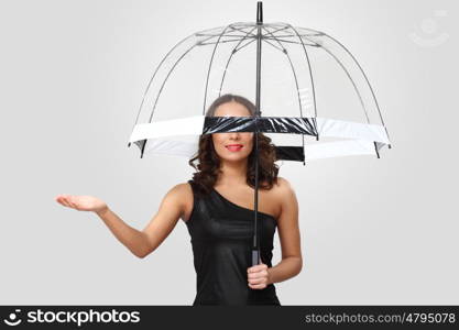 Studio portrait of woman in black dress with umbrella