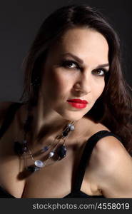 Studio portrait of young beautiful woman against black background