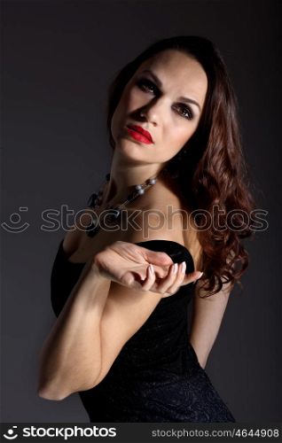 Studio portrait of young beautiful woman against black background