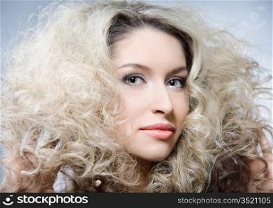 studio portrait of young caucasian woman with curly hair