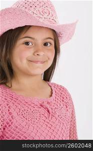Studio portrait of young girl wearing pink cowgirl hat