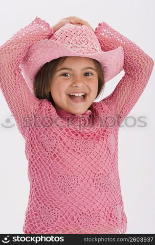 Studio portrait of young girl wearing pink cowgirl hat