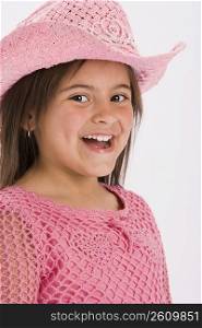 Studio portrait of young girl wearing pink cowgirl hat