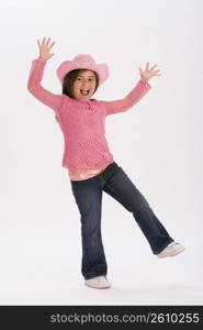 Studio portrait of young girl wearing pink cowgirl hat