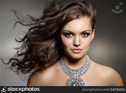 studio portrait of young gorgeous brunette with evening make up