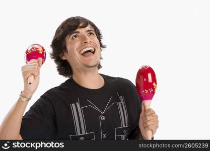 Studio portrait of young man dancing with maracas