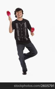 Studio portrait of young man dancing with maracas