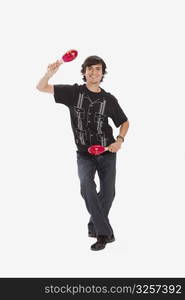 Studio portrait of young man dancing with maracas