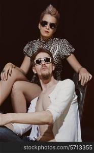 Studio portrait of young men and women wearing a stylish sunglasses on black background