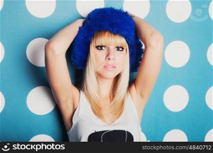 Studio portrait of young woman dressed in blue winter hat. Fashion modern style