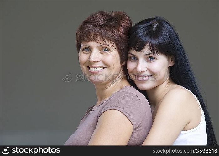 Studio portrait of young woman embracing mother