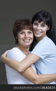 Studio portrait of young woman embracing mother