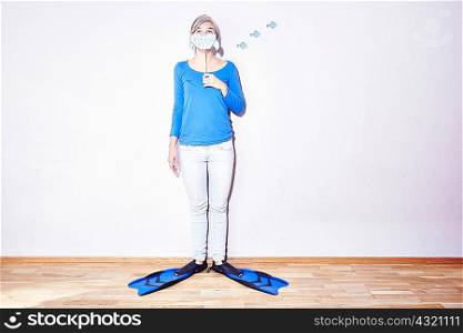 Studio portrait of young woman wearing flippers holding up drawing of sharks mouth