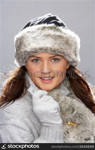 Studio Portrait Of Young Woman Wearing Fur Hat And Wrap