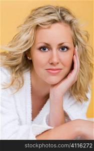 Studio shot beautiful young blond woman wearing a bathrobe looking restful and relaxed
