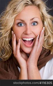 Studio shot beautiful young blond woman wearing looking happily surprised