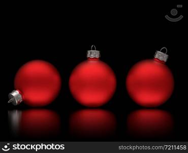 Studio shot close-up of three vintage red and matte traditional Christmas baubles with shadow on black glossy background with copy space