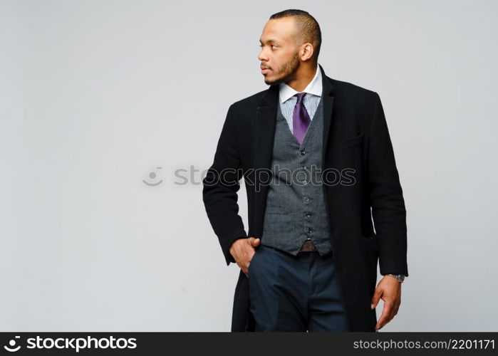 studio shot of a african-american businessman wearing coat over light grey background.. studio shot of a african-american businessman wearing coat over light grey background