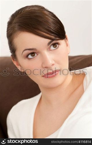Studio shot of a beautiful young brunette woman with striking brown eyes and an enigmatic smile.