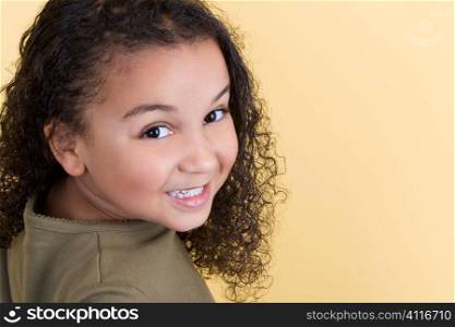 Studio shot of a beautiful young mixed race girl smiling and looking back over her shoulder