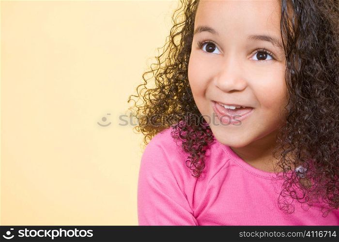 Studio shot of a beautiful young mixed race girl smiling and looking up