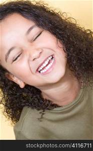 Studio shot of a beautiful young mixed race girl smiling and showing off her perfect white teeth