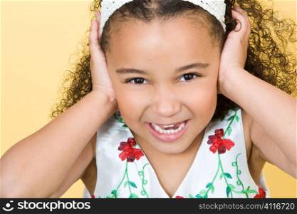 Studio shot of a beautiful young mixed race girl with her hands over her ears