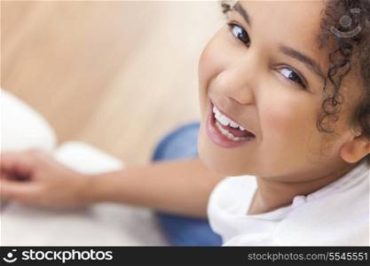Studio shot of a beautiful young mixed race interracial African American girl child smiling and showing off her perfect white teeth