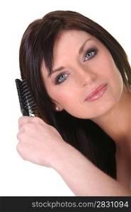 Studio shot of a brunette brushing her hair