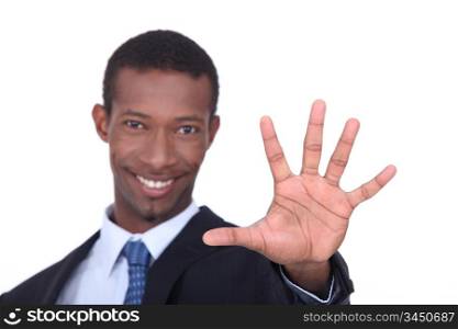 Studio shot of a businessman with the palm of his hand outstretched in front of him