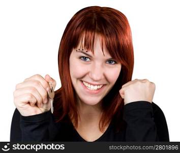 Studio shot of a cute redhead girl holding home or car keys and smiling her success out.