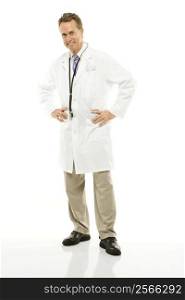 Studio shot of a mid-adult Caucasian male doctor with hands on his hips.