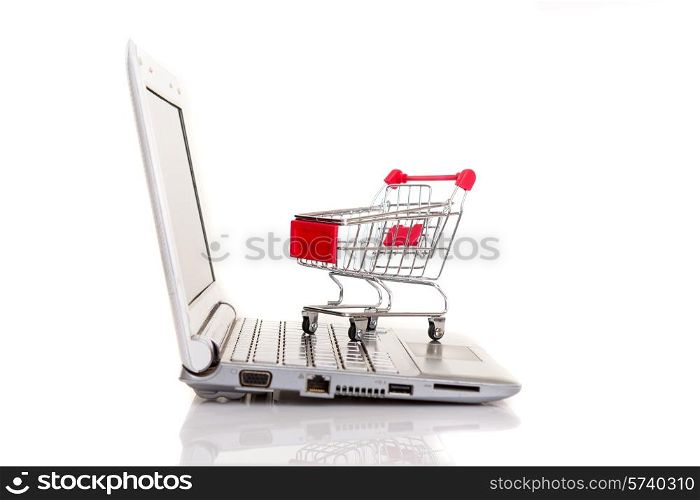 Studio shot of a shopping cart over a laptop computer
