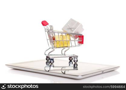Studio shot of a shopping cart over a tablet computer
