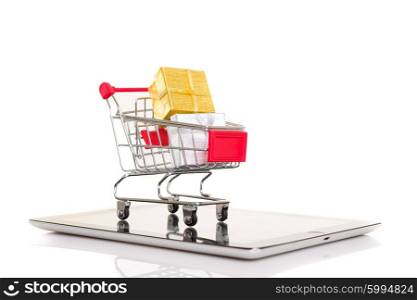 Studio shot of a shopping cart over a tablet computer