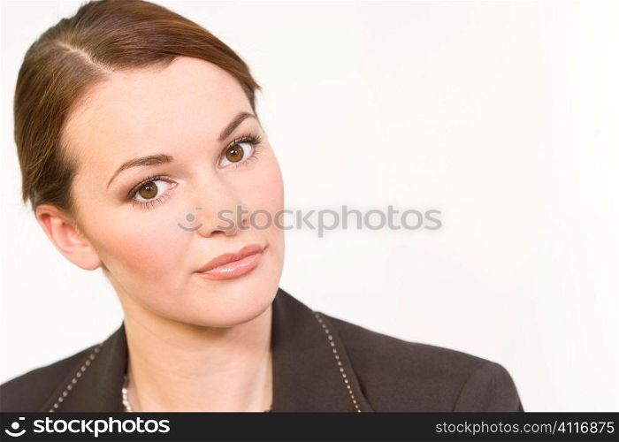 Studio shot of a smartly dressed beautiful young brunette woman with striking brown eyes looking thoughtful