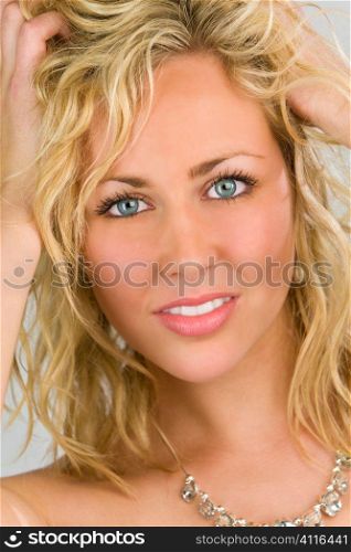 Studio shot of a stunningl beautiful blue eyed model running her fingers through her blond hair